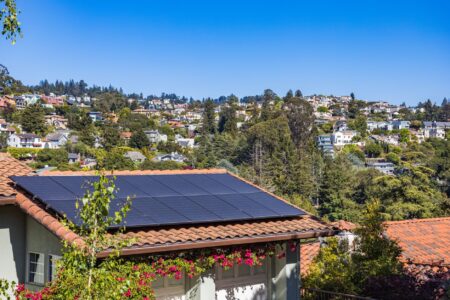 Residential solar panels installed on a suburban rooftop under bright sunlight