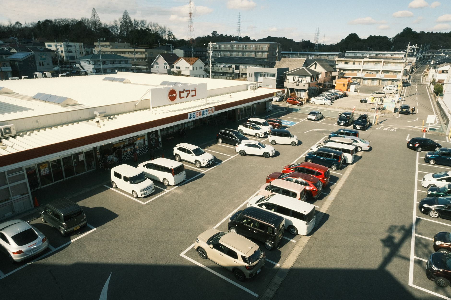 Row of used cars parked at a dealership lot with price stickers on windshields