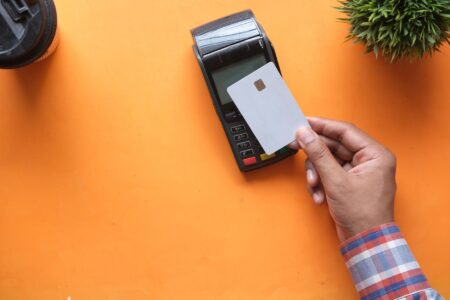Person holding a credit card while reviewing a bill at a desk