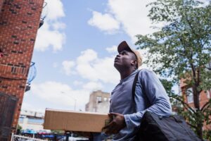 Gig Worker Misclassification Crackdowns Strain Platform Business Models A gig economy delivery worker on a bicycle carrying a food delivery bag in an urban setting