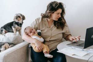 Child Care Subsidy Cliffs Push Working Parents Off Benefits Early A working mother sits at a desk with paperwork, representing the financial pressures facing working parents navigating child care costs