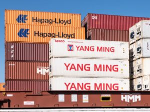 Rows of shipping containers stacked at a commercial port terminal