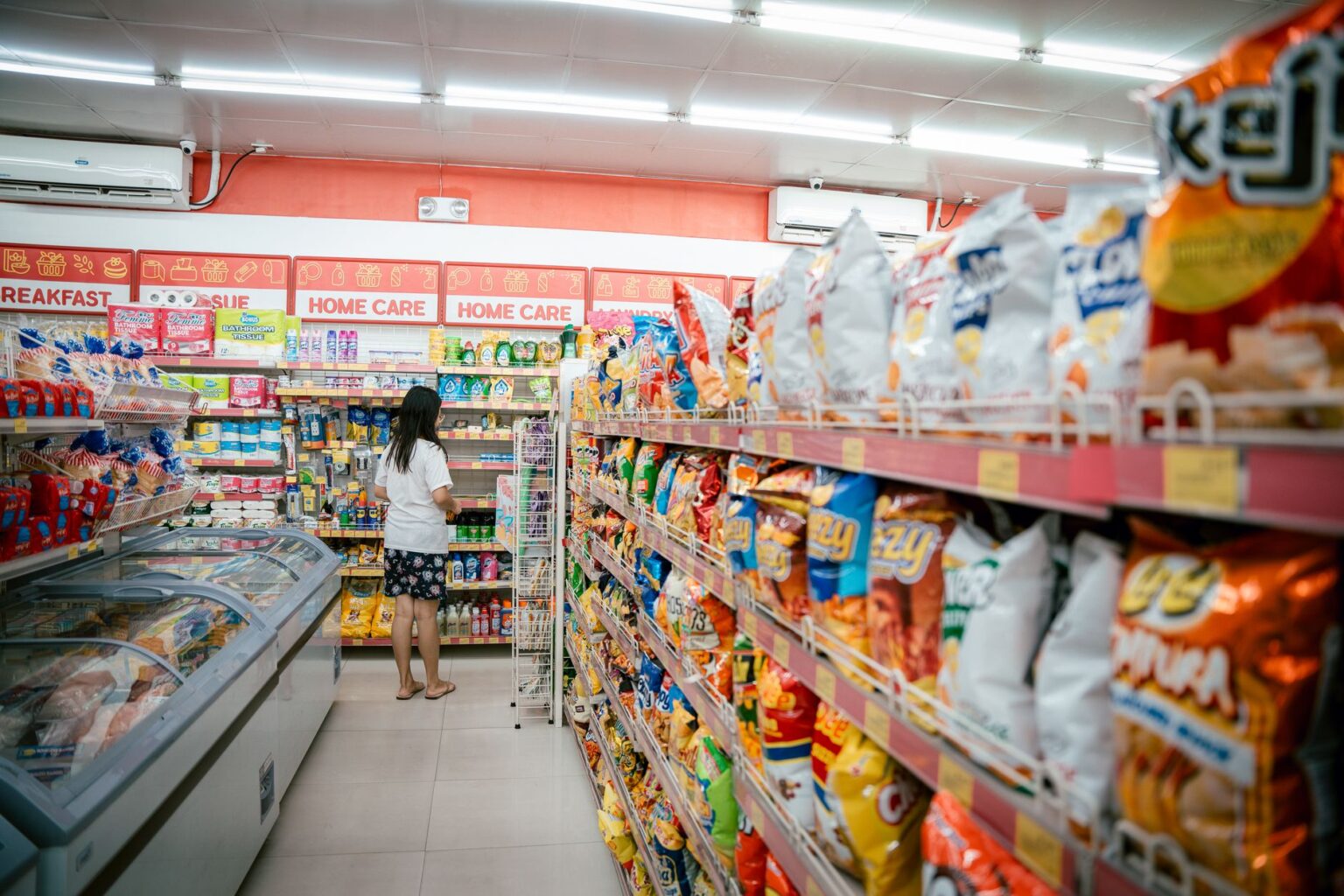 Grocery store aisle with shelves stocked with packaged food staples