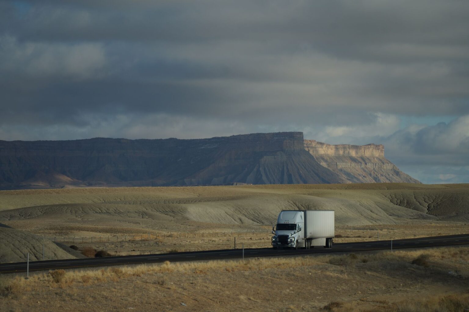 Commercial Trucking Insurance Premiums Surge as Crash Liability Costs Mount Commercial semi truck driving on a highway representing rising trucking insurance costs