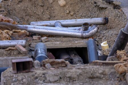 Water Utility Rate Hikes Accelerate as Infrastructure Debt Mounts Aging underground water pipes showing wear and corrosion beneath a city street