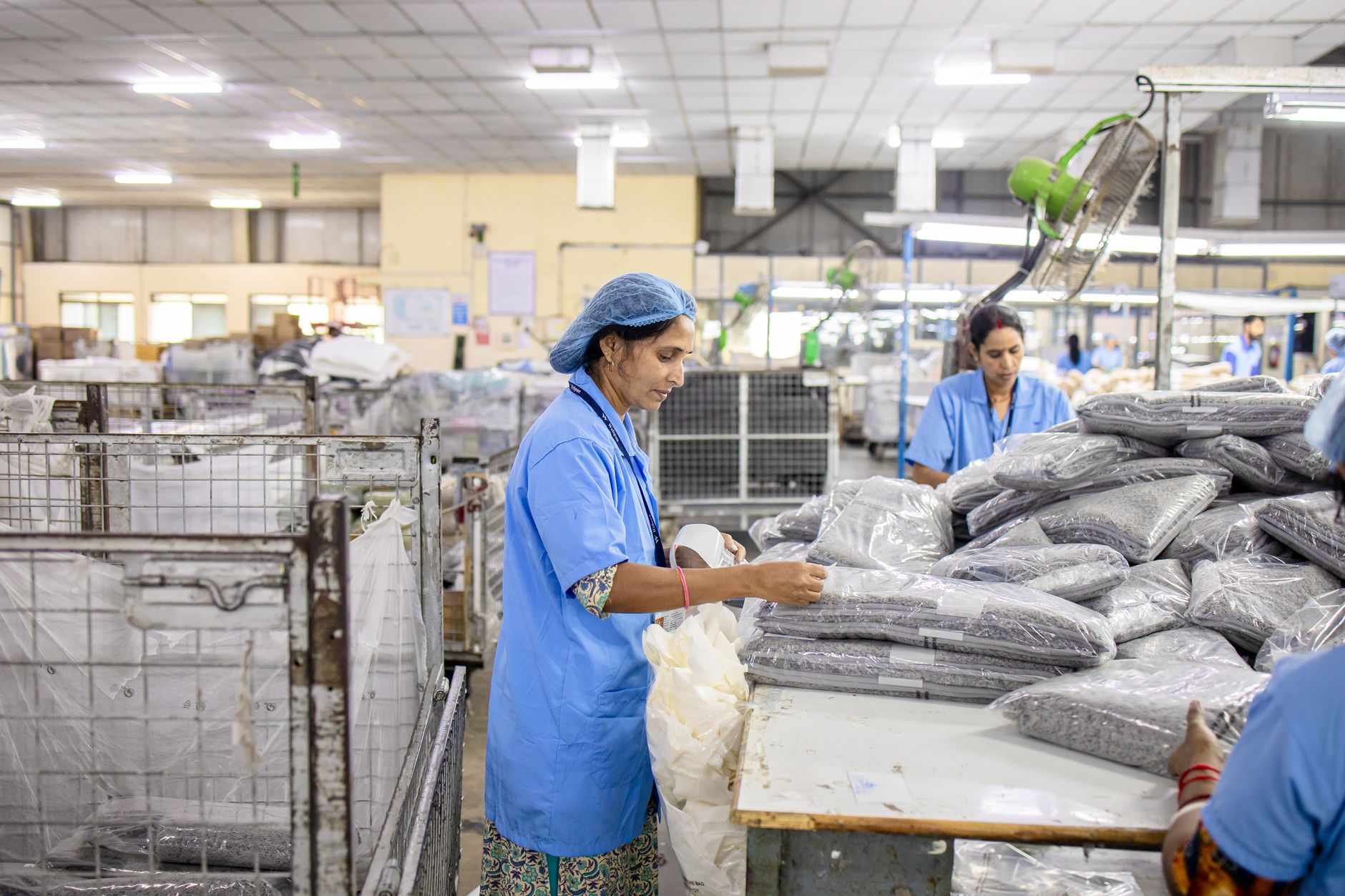 Workers sorting packages on a conveyor belt inside a large distribution warehouse