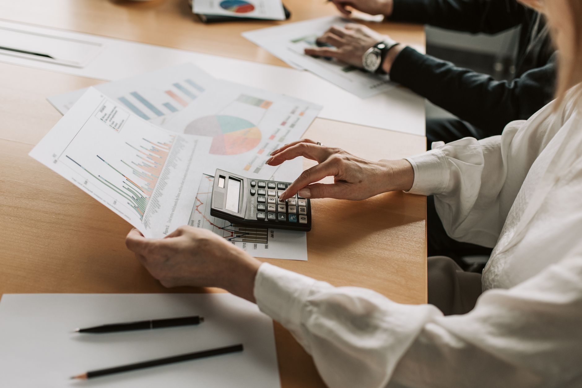 Business professionals reviewing financial documents and capital budget plans at a conference table