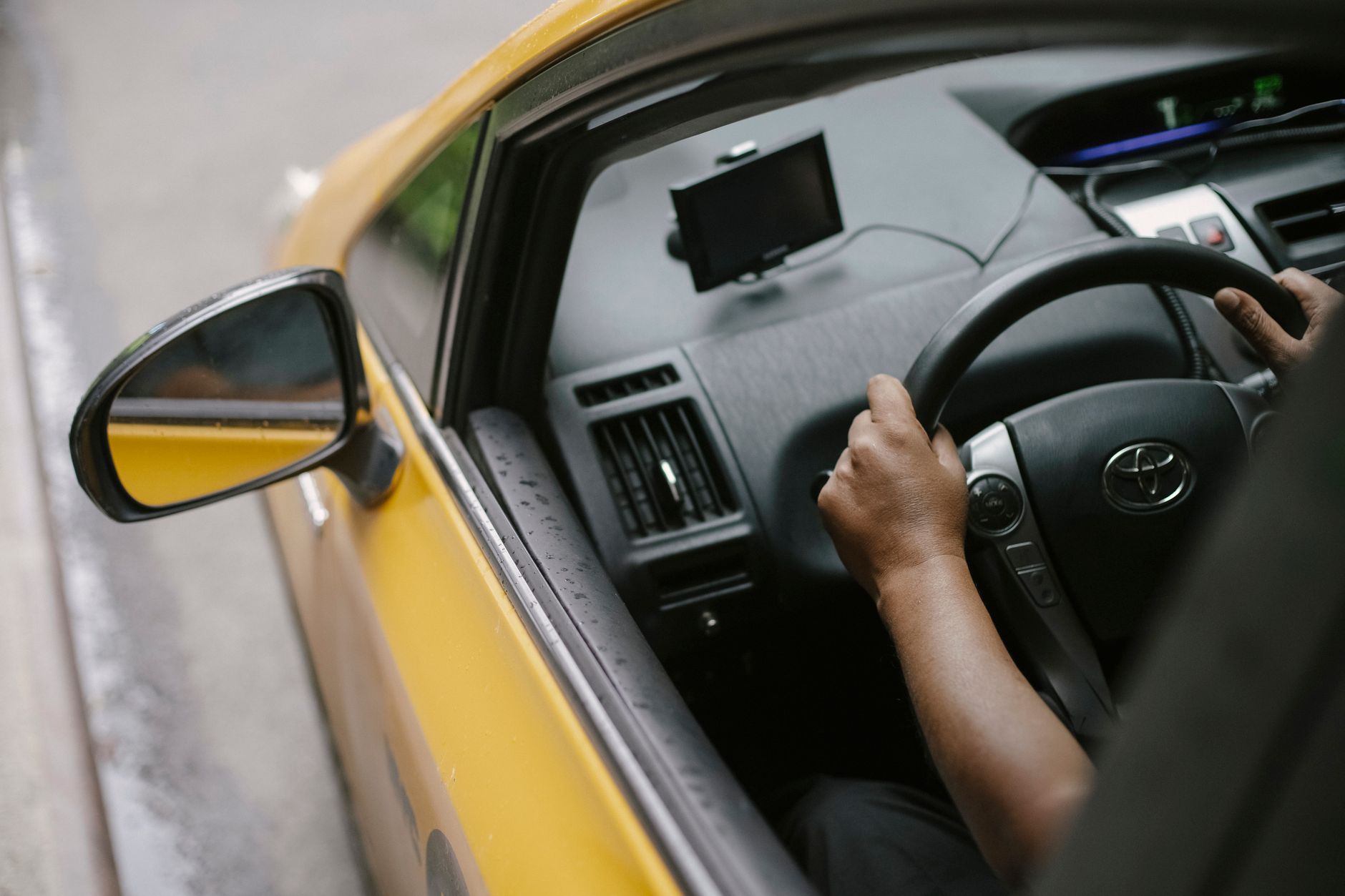 A rideshare driver sitting in their vehicle waiting for a ride request on a mobile app