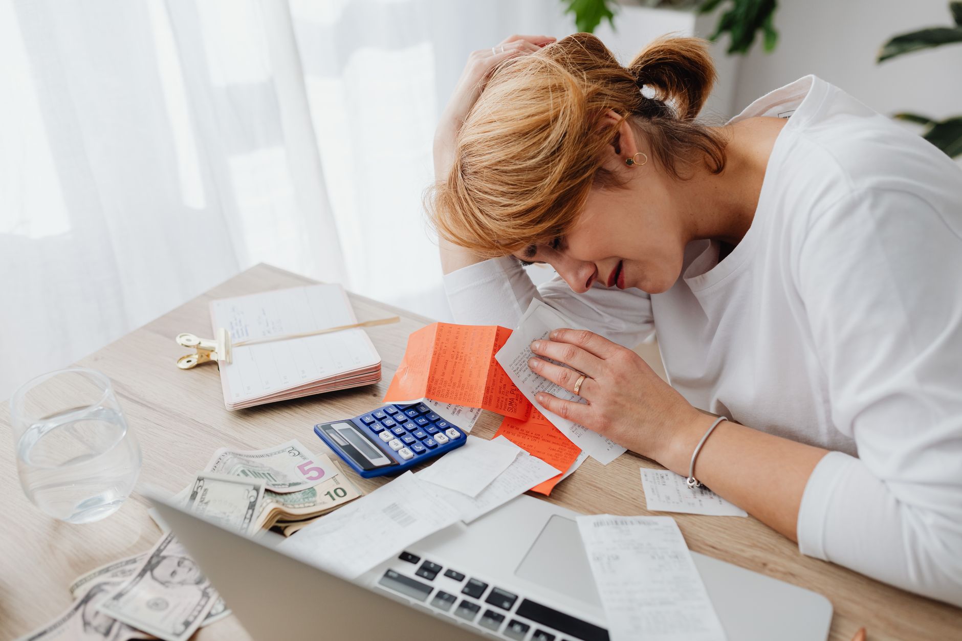 A person reviewing financial documents with a stressed expression, representing the household budget strain caused by losing child care subsidies