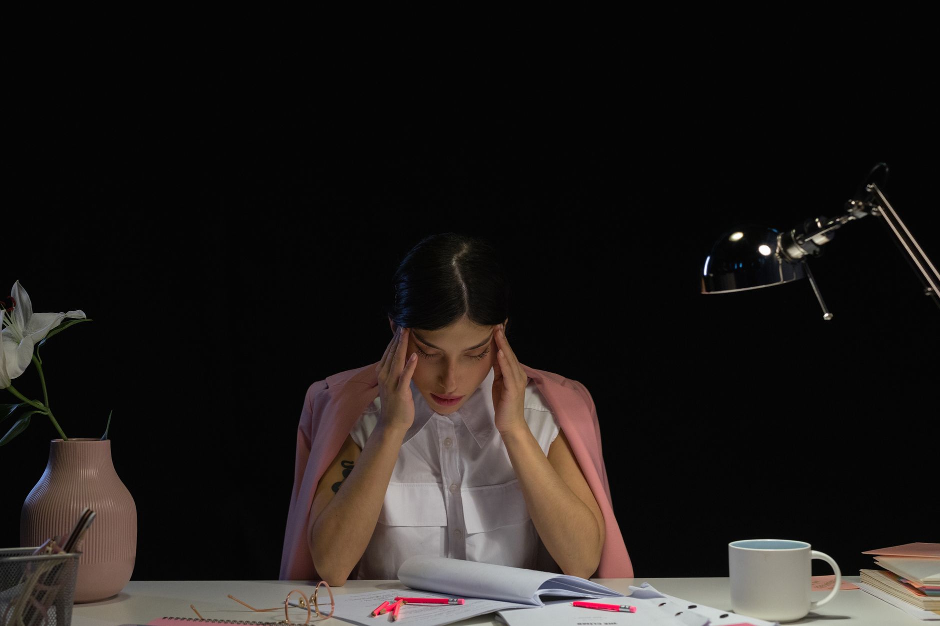 Worker sitting at desk looking at financial documents with concern