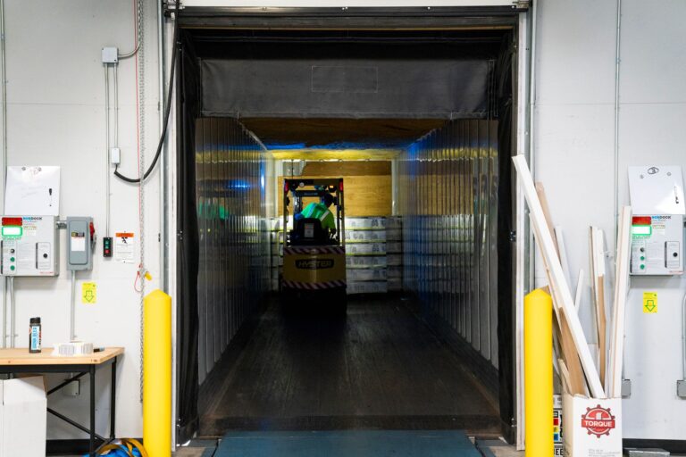 Large empty warehouse interior with high ceilings and loading dock doors