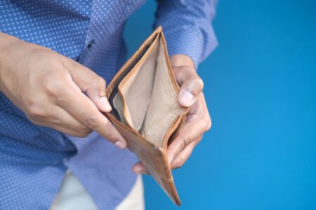Payday Loan Rollover Rates Climb as Overdraft Fee Caps Bite Empty wallet held open showing no cash, representing financial shortfall