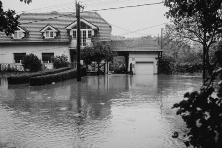 Flood Insurance Premium Spikes Strain Coastal Homeowner Budgets Floodwater surrounding a residential home on a coastal street
