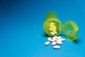 Prescription medication bottles on a pharmacy counter representing drug cost burden