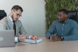 Visa Sponsorship Freezes Quietly Reshape High-Skill Hiring Markets Two professionals meeting across a desk during a job interview in a modern office setting