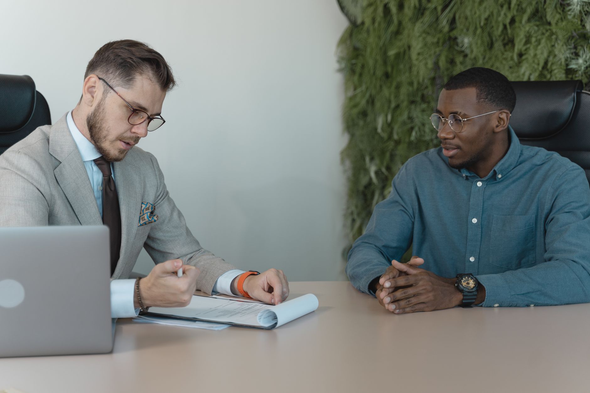 Two professionals meeting across a desk during a job interview in a modern office setting