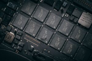 Semiconductor Inventory Glut Pressures Chipmaker Margins Into 2026 Workers on a semiconductor manufacturing floor surrounded by chip production equipment