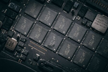 Semiconductor Inventory Glut Pressures Chipmaker Margins Into 2026 Workers on a semiconductor manufacturing floor surrounded by chip production equipment