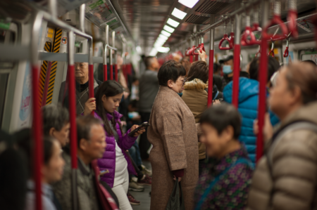 Commuters crowding a busy urban subway platform during morning rush hour