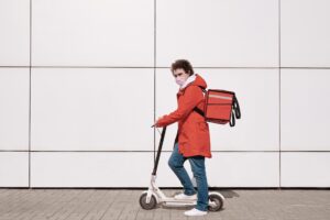 A gig worker on a bicycle delivering goods in an urban setting