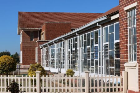 School District Budget Cuts Deepen as Property Tax Appeals Surge Exterior of a public school building on a quiet street