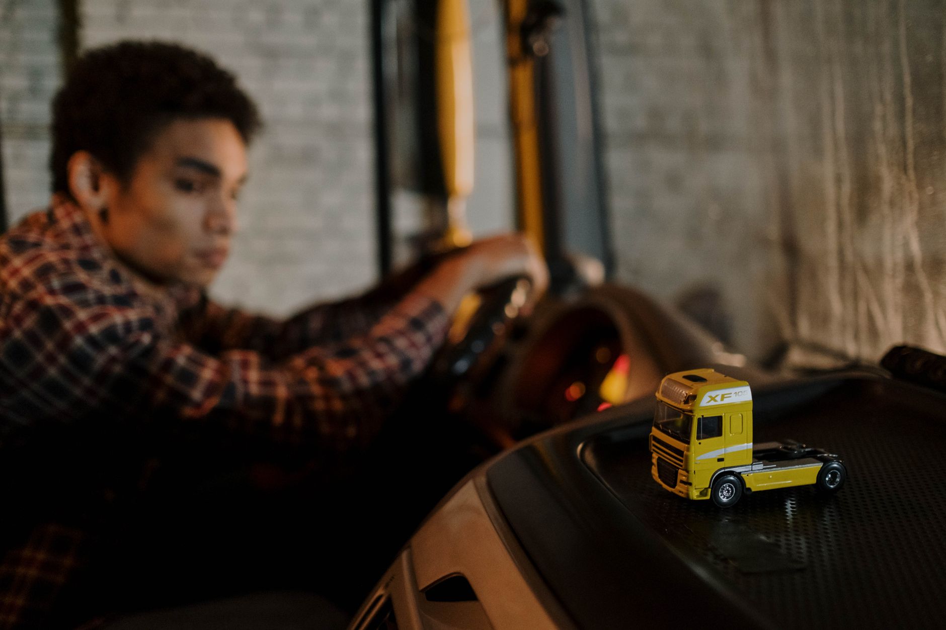 A truck driver sitting in the cab of a commercial freight vehicle