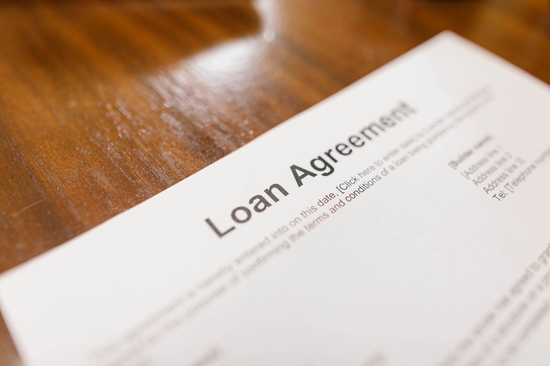 Person signing a short-term loan document at a desk