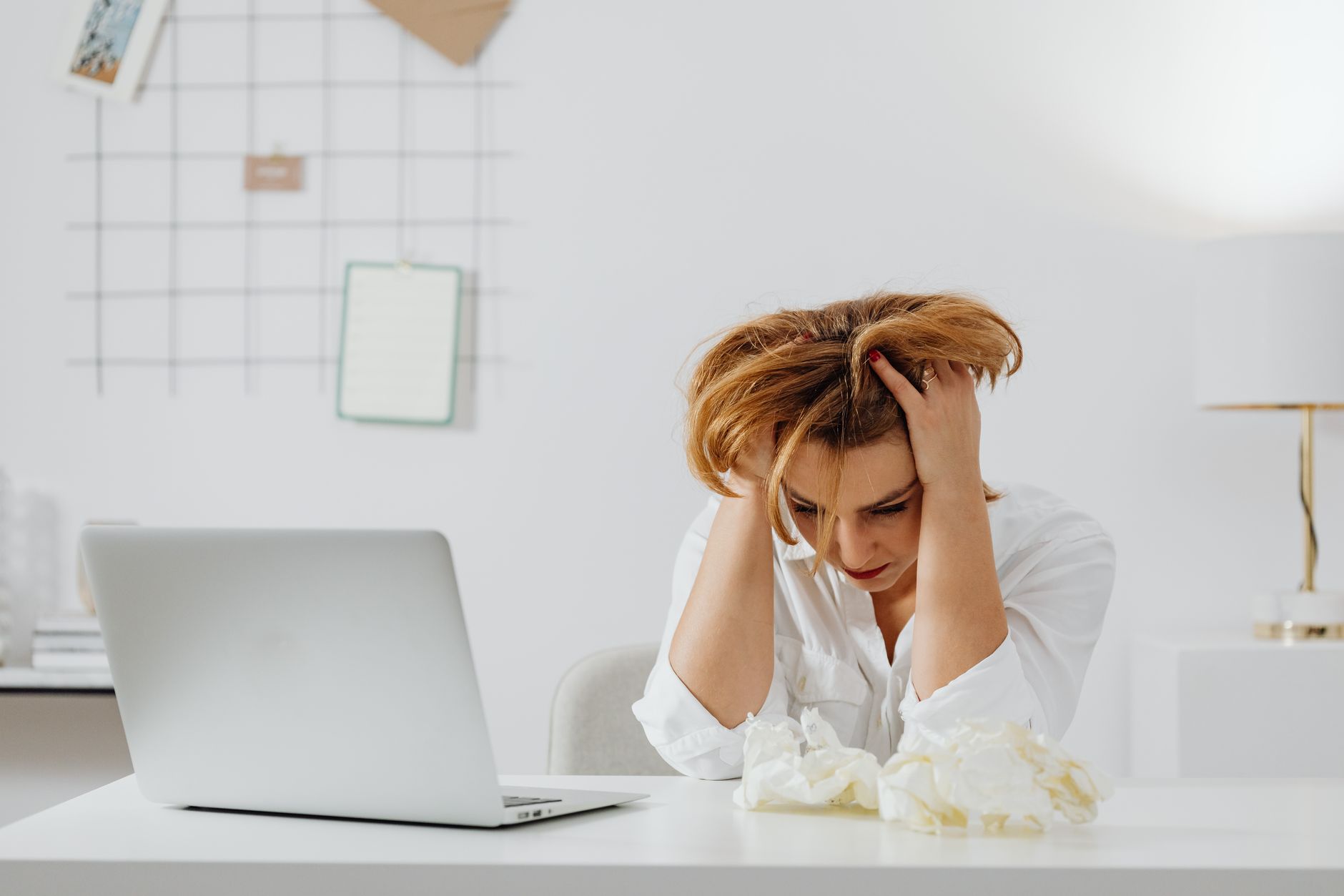 Person surrounded by paperwork at a desk, representing rental assistance application challenges