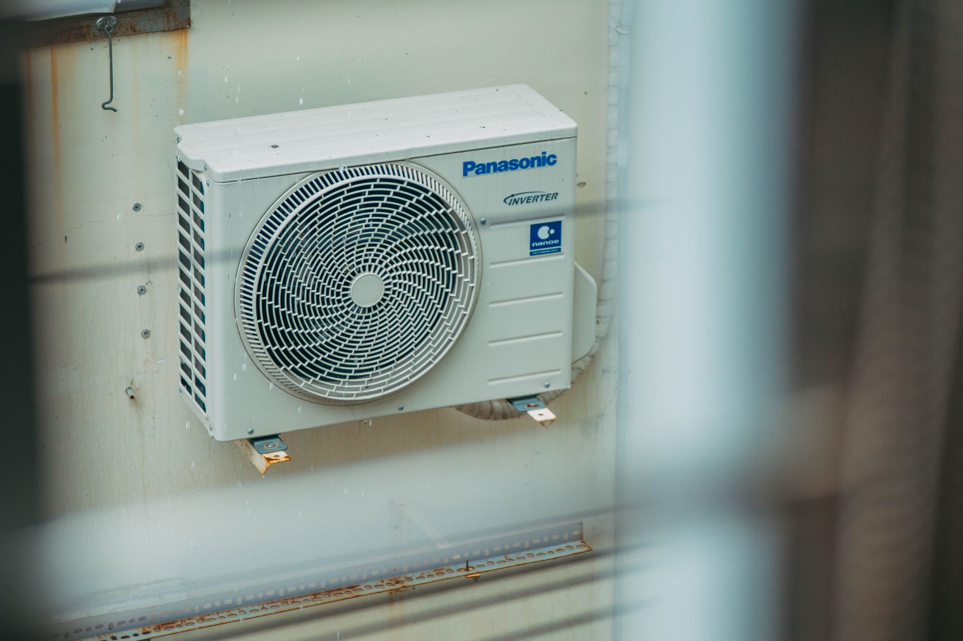 An electric heat pump unit installed on the exterior wall of a home