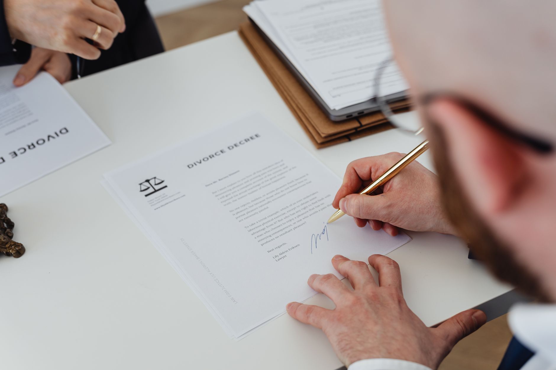Person reviewing and signing a consumer contract at a desk