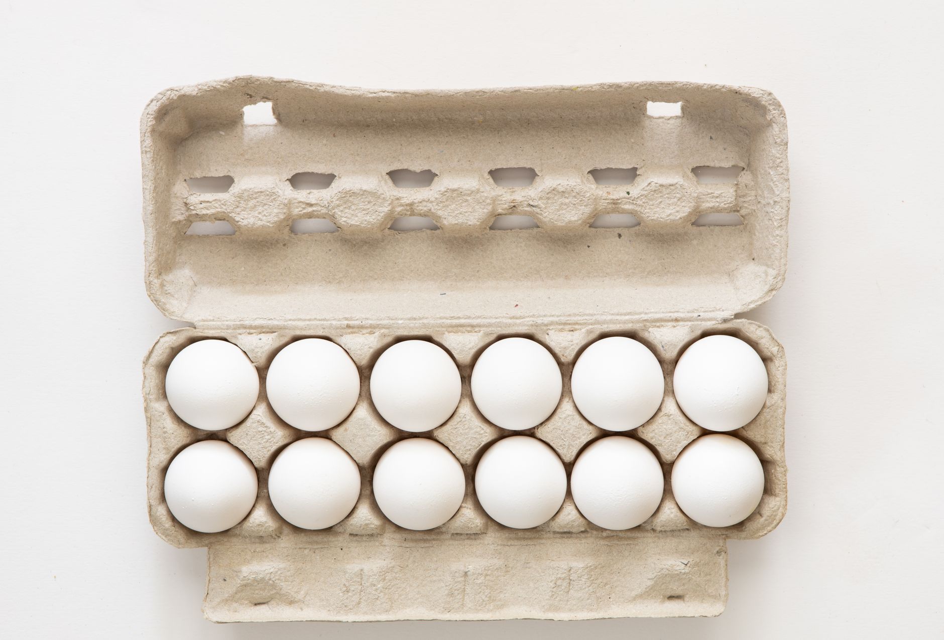 Stacked egg cartons on a grocery store shelf showing retail egg supply
