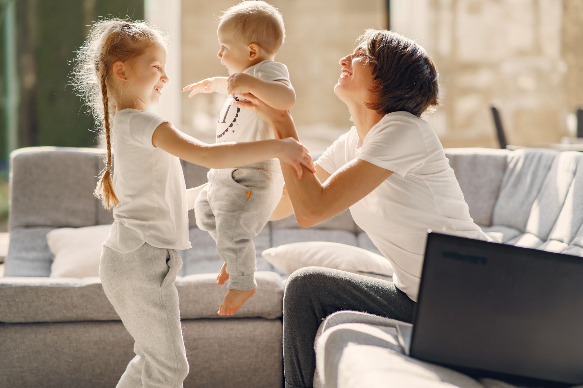 A childcare worker sitting with toddlers during an activity session indoors