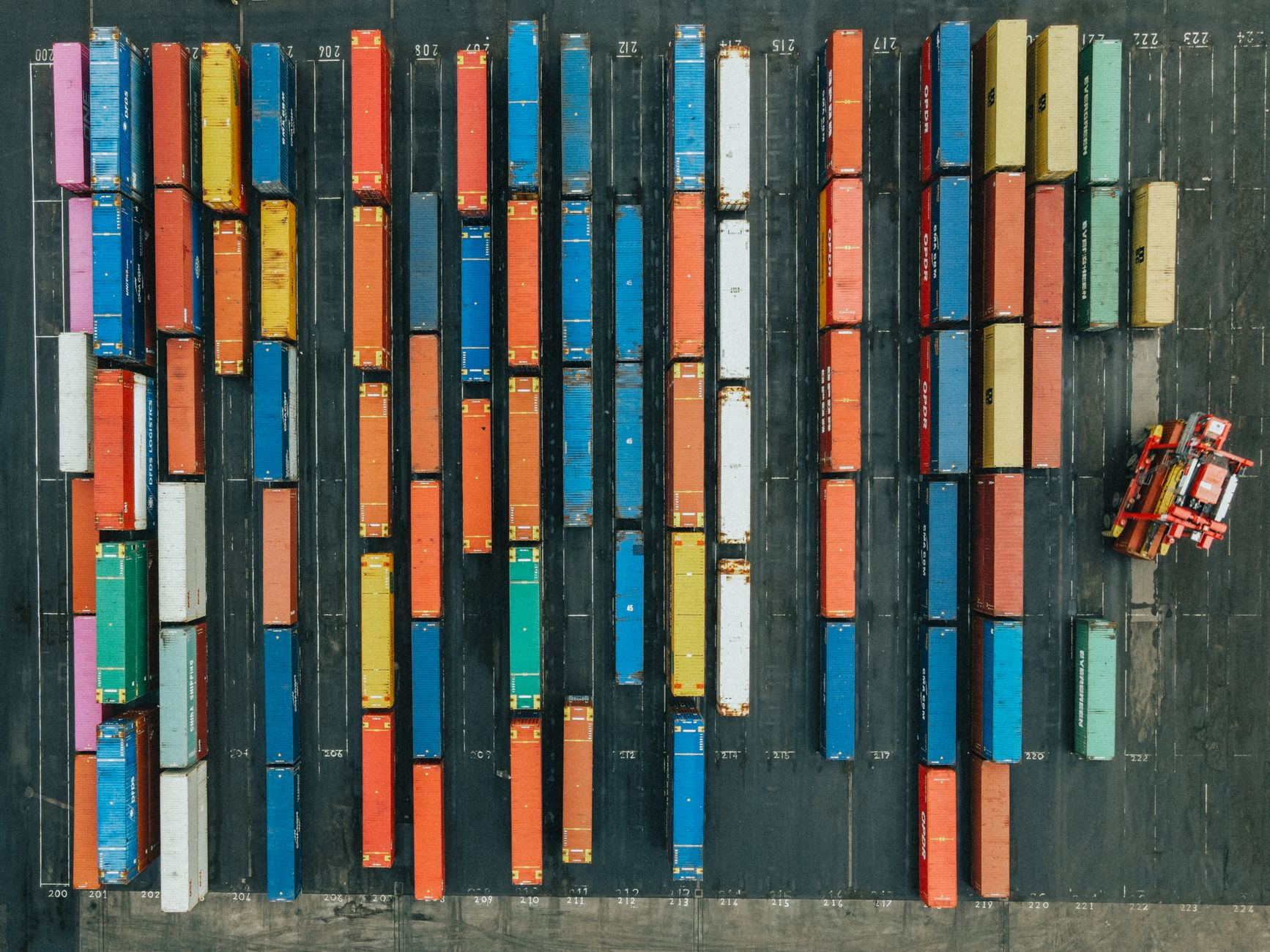 Aerial view of colorful shipping containers stacked at a freight terminal
