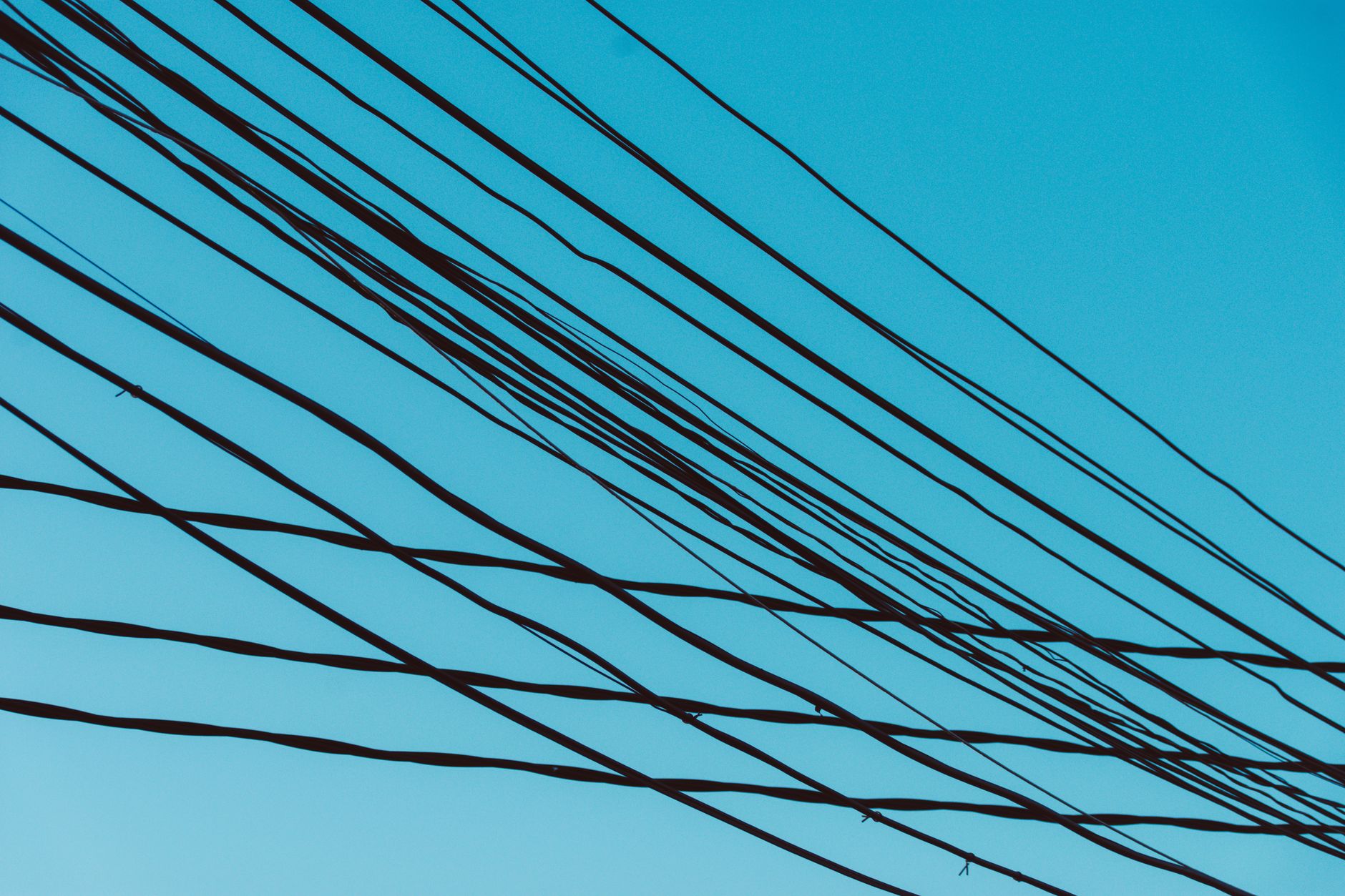 High-voltage transmission lines and electricity pylons stretching across open land