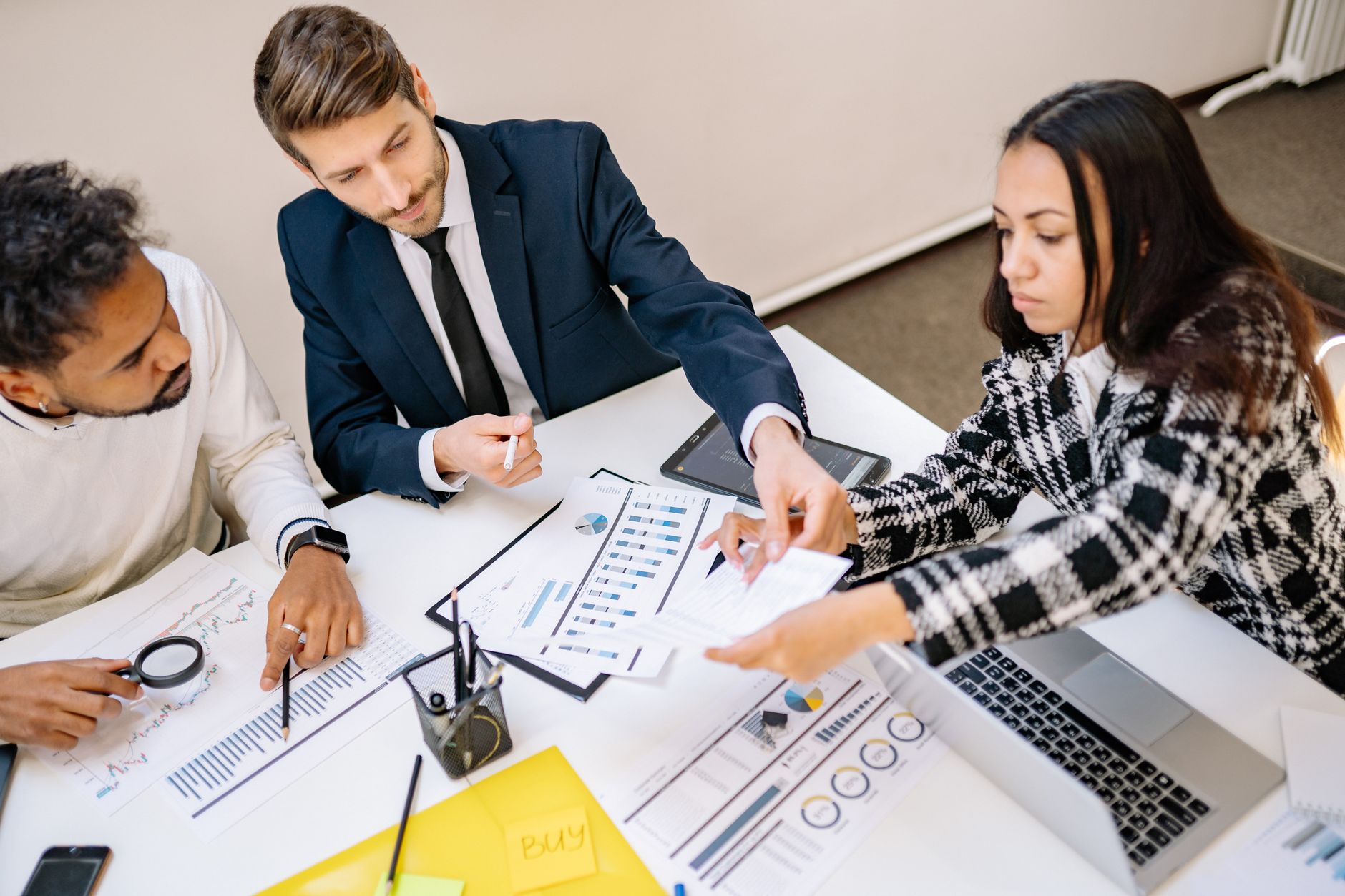 Corporate executives reviewing site selection documents in a conference room