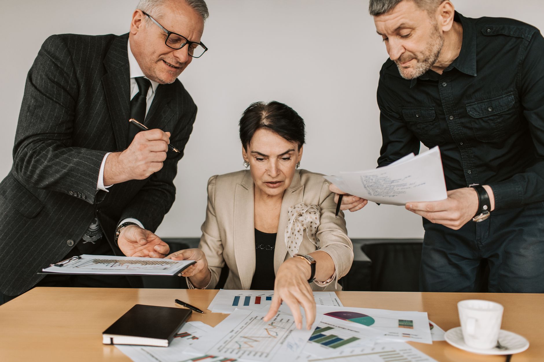 Bank executives reviewing documents during a merger negotiation meeting