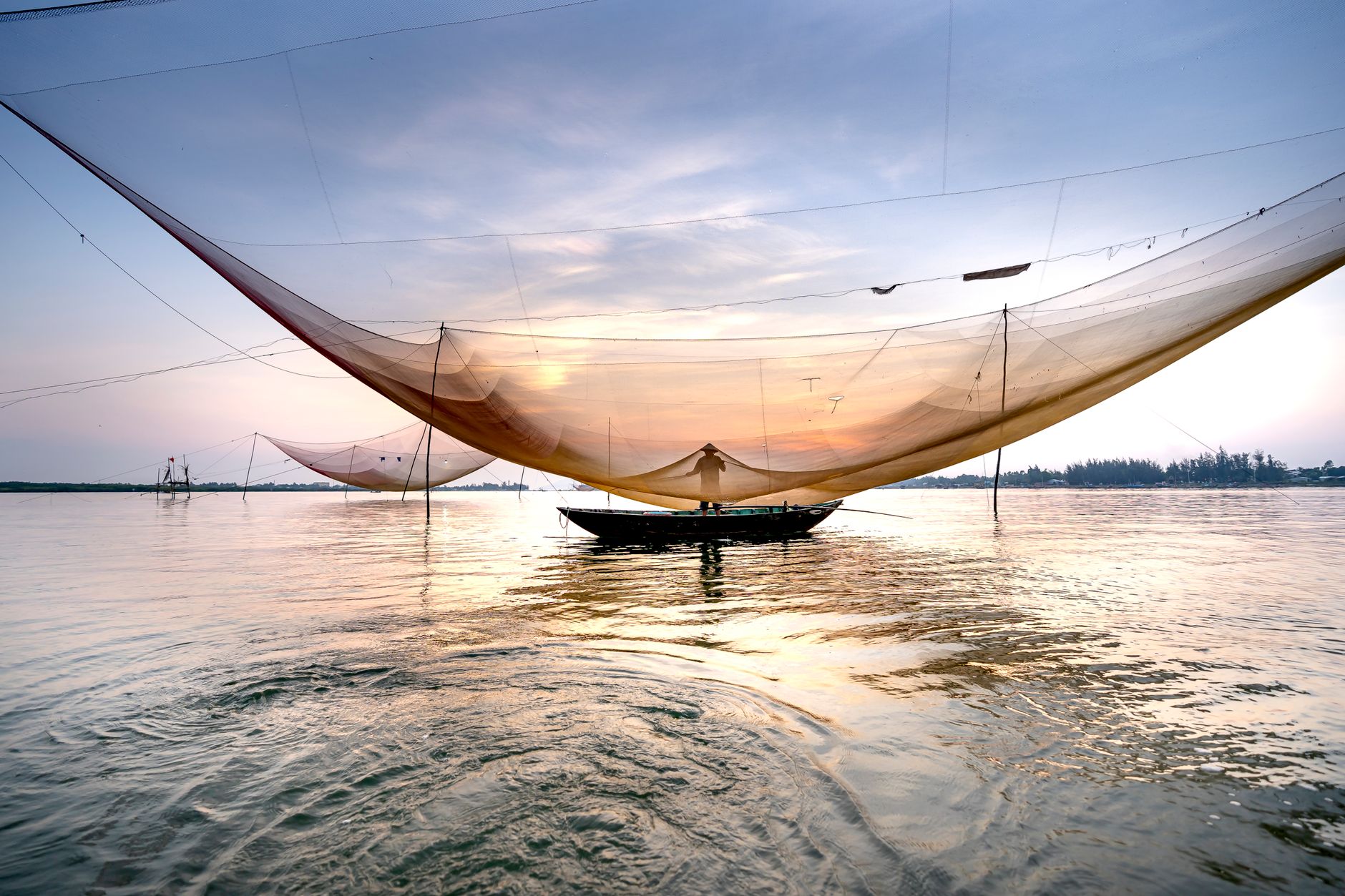 Commercial fisherman hauling a net on a small fishing vessel