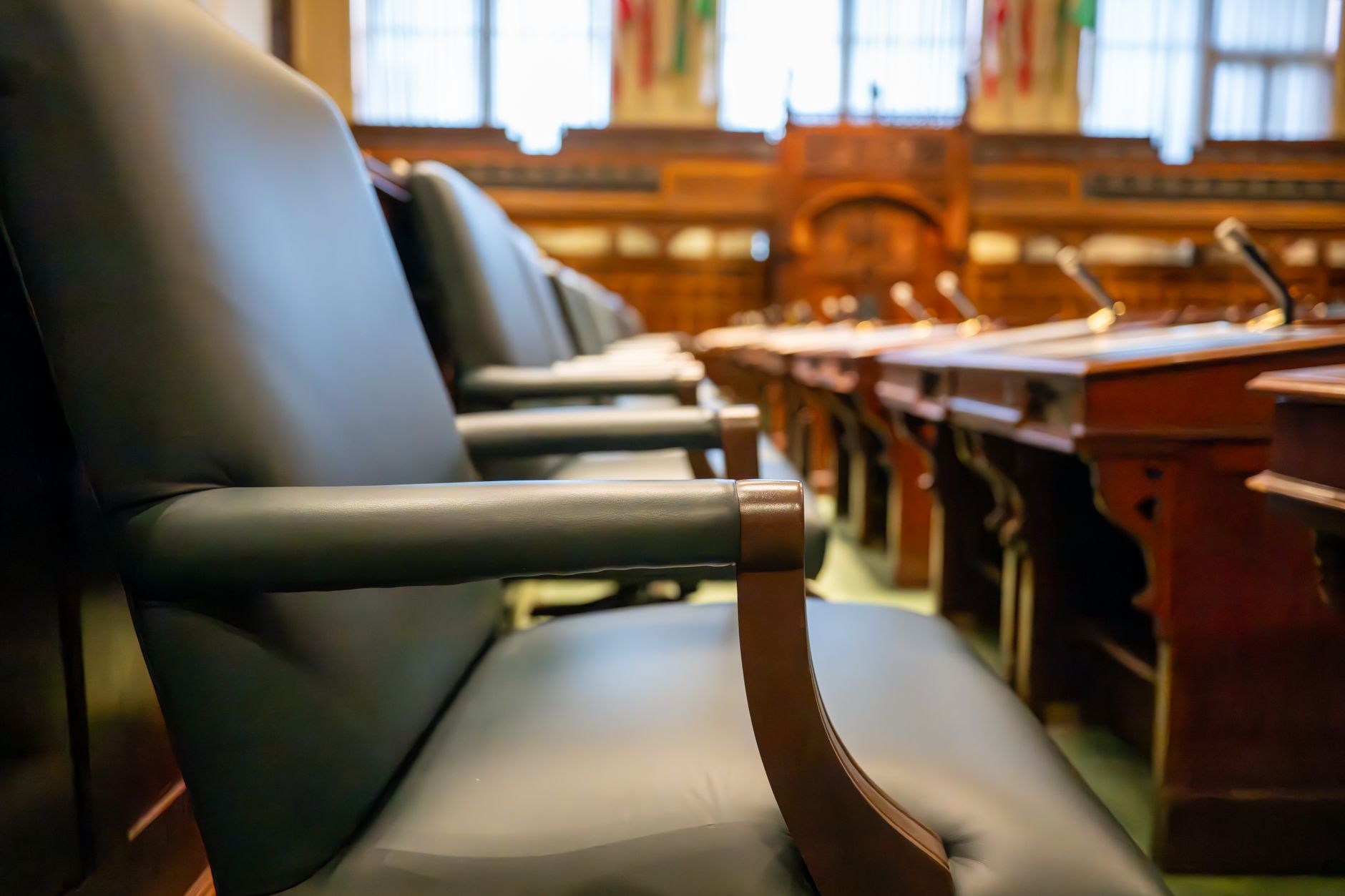 State legislature hearing room with lawmakers seated at formal committee table