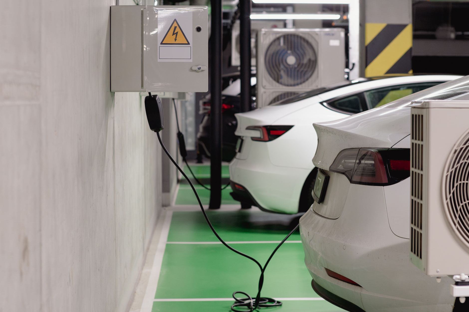 Electric vehicle plugged into a public charging station in an urban setting