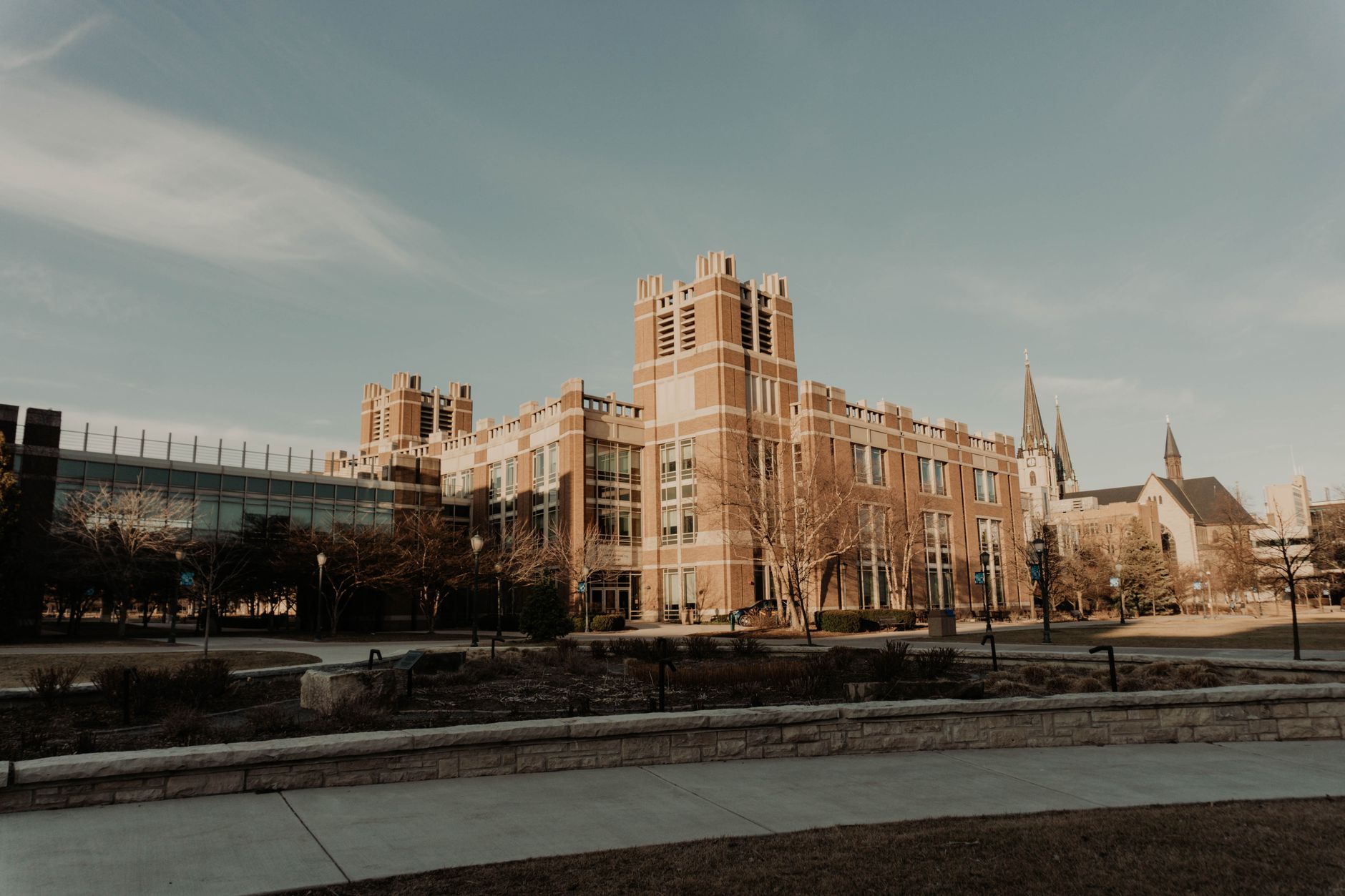 Students walking across a college campus in spring