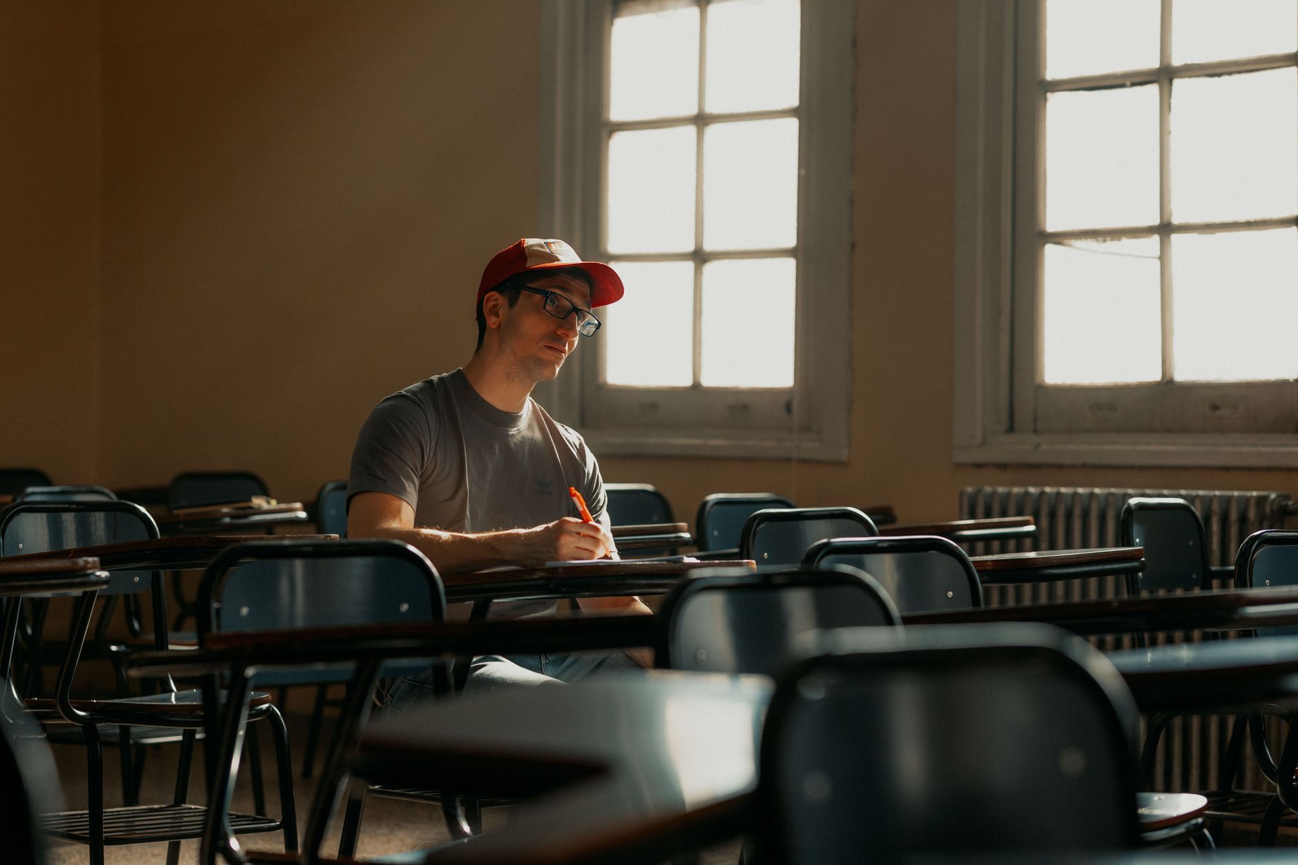 A college student sitting alone reviewing documents and paperwork