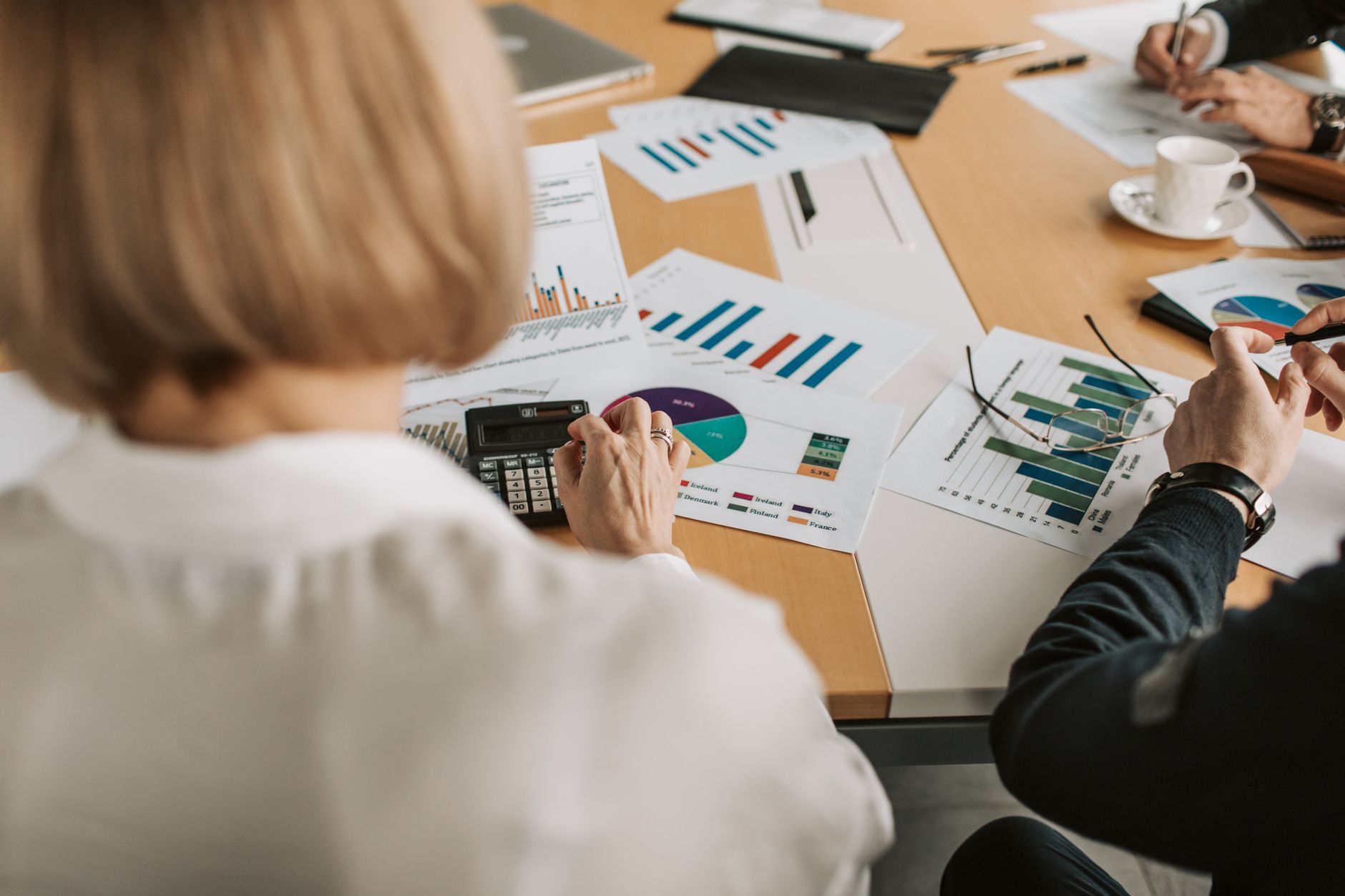 Business professionals reviewing financial documents and charts during a formal meeting