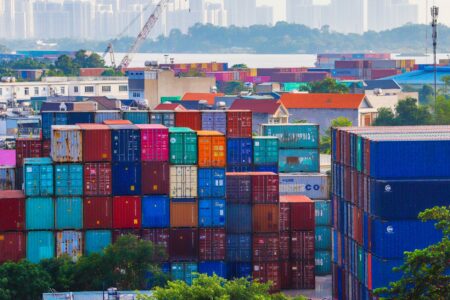 Aerial view of a busy shipping port with stacked cargo containers