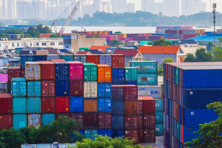 Aerial view of a busy shipping port with stacked cargo containers