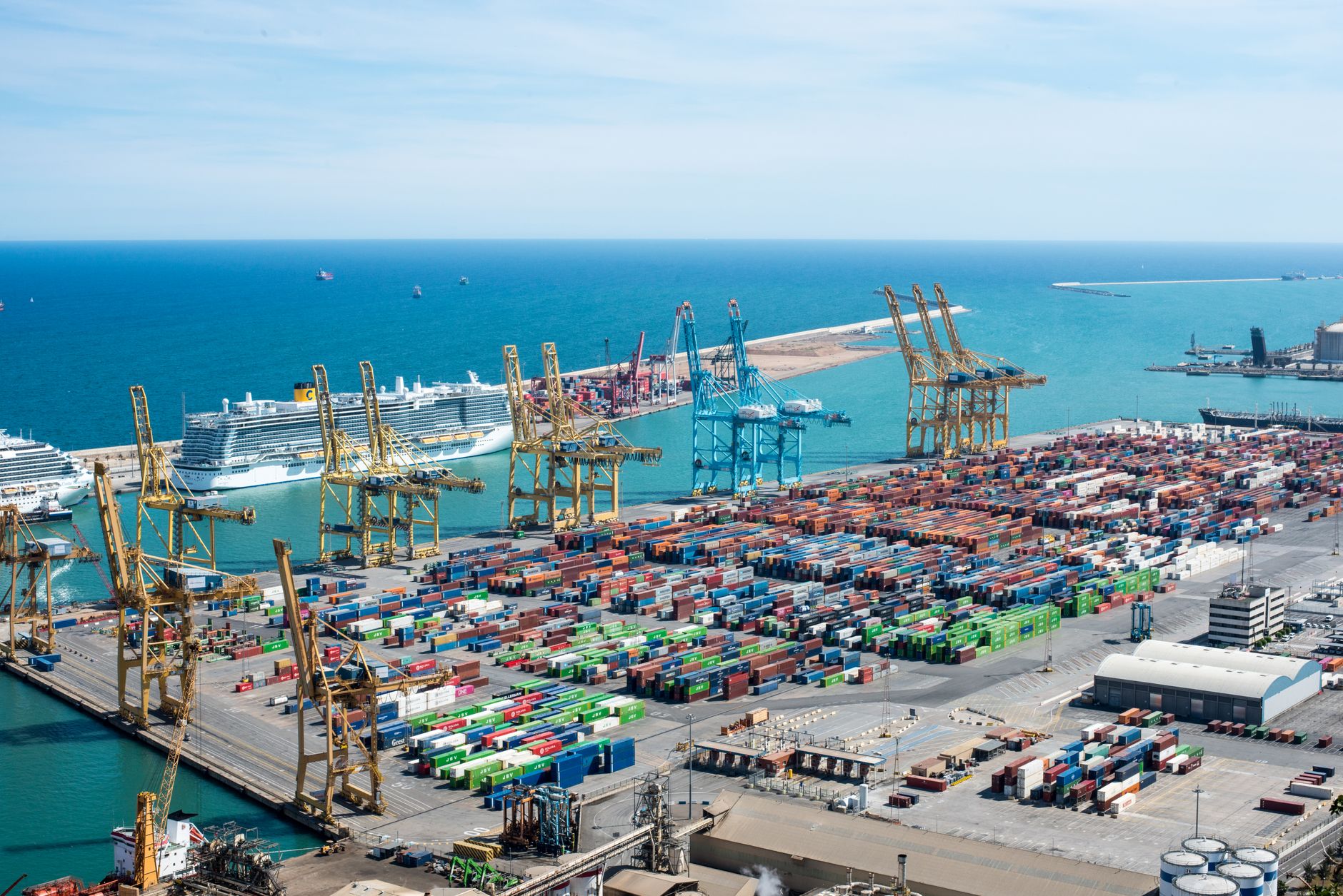 Aerial view of a small regional cargo port with shipping containers and cranes