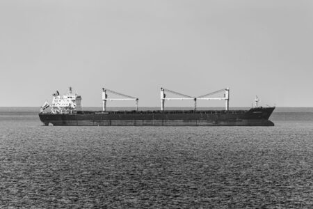 Large cargo container ship sailing through open ocean waters