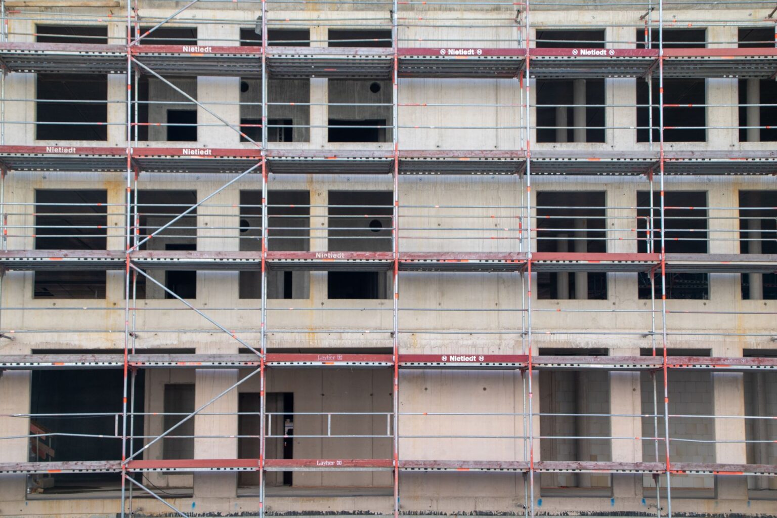 Hotel Construction Debt Piles Up as Business Travel Demand Plateaus Aerial view of a large hotel under construction with cranes and scaffolding visible