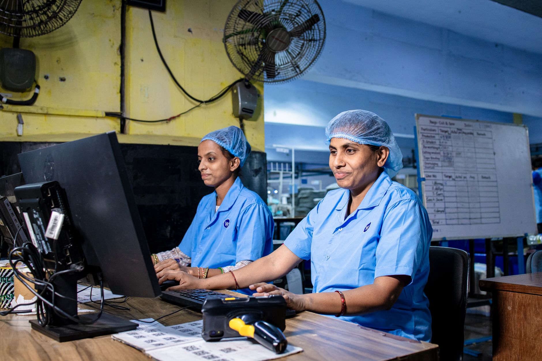 Workers on a small manufacturing factory floor operating industrial equipment