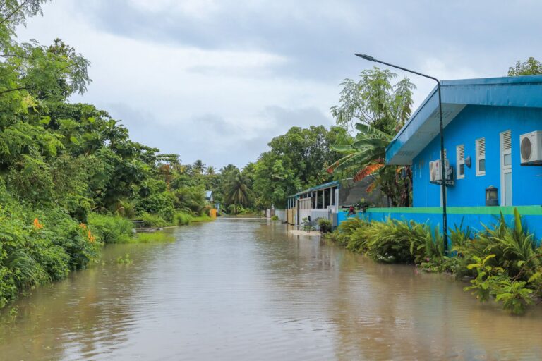 Flooded coastal street with water surrounding residential homes