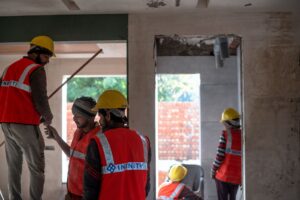 Construction workers on a residential building site with scaffolding and framing visible